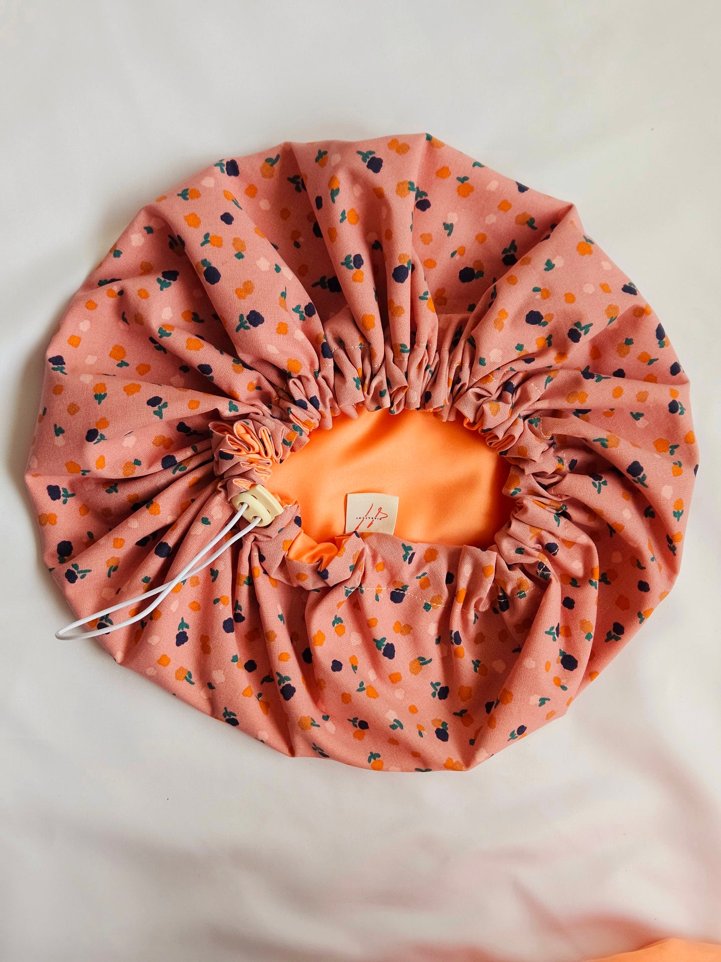 Haube aus Satin-Lachs und Blümchen